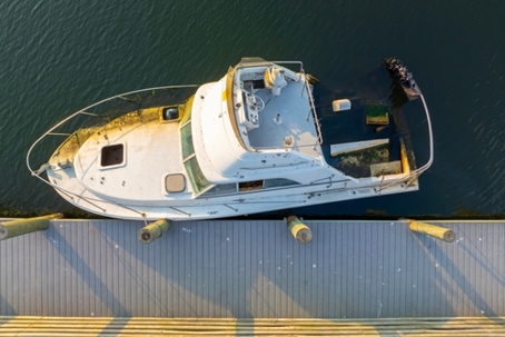 Half sunken sailing yacht capsized on shallow bay waters after hurricane Ian in Manasota, Florida