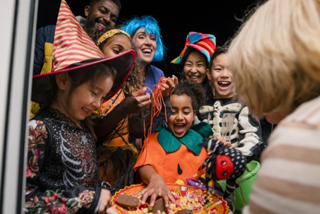 Two families wearing fancy dress, out trick or treating during Halloween | Scott Law Firm