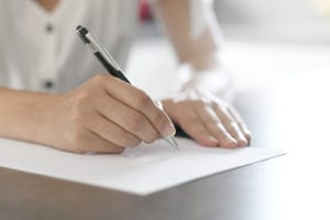 Woman writing on a Piece of Papar